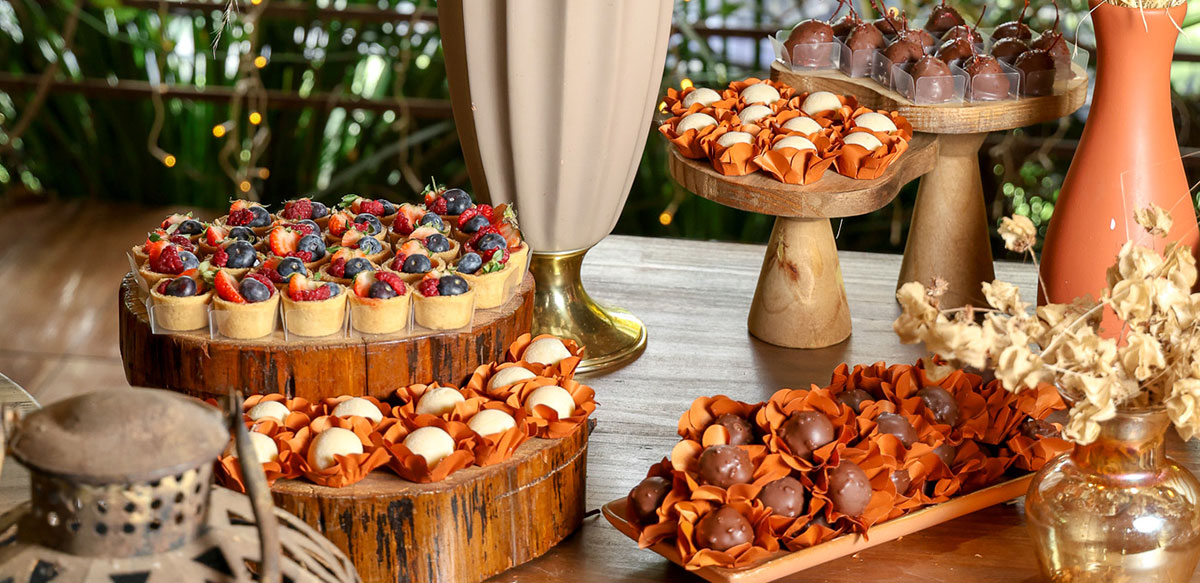 Composição de mesa com doces finos, tortinhas e brigadeiros